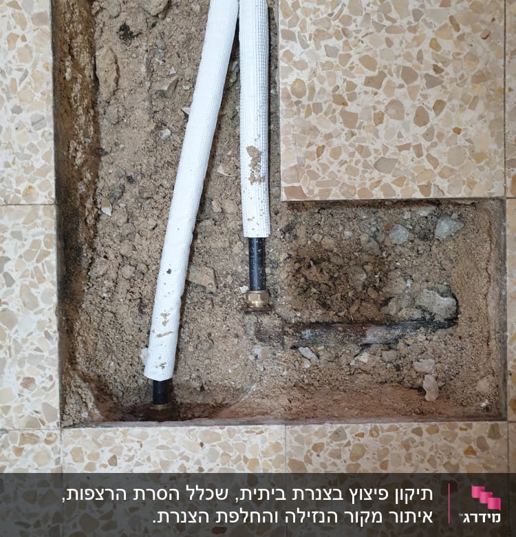 צינורות מים חשופים בתוך רצפה שבורה